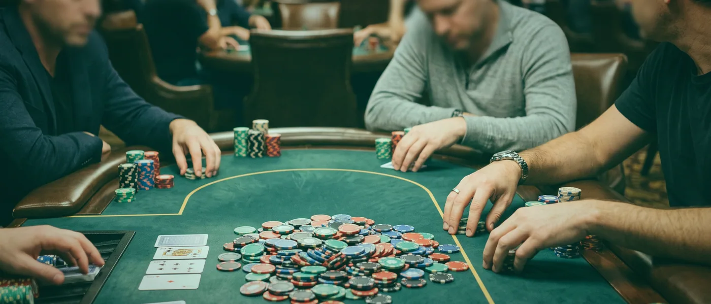 A dealer’s hands fanning a fresh deck across the felt at a Silver Wattles card table